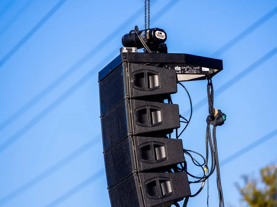 Caixas de som line array içadas em estrutura para evento ao ar livre